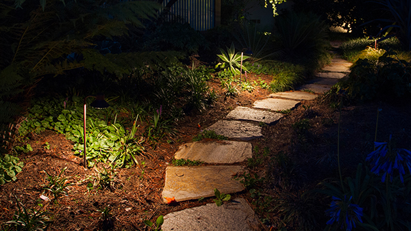 Illuminated Outdoor Light Fixtures Along Stone Pathway